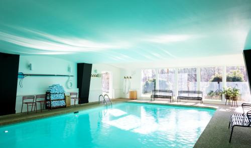 斯托Tälta Lodge, a Bluebird by Lark的一个带椅子和大窗户的大型游泳池
