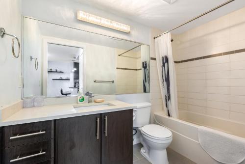 温哥华Downtown 1 Bedroom Water View Condo的浴室配有盥洗盆、卫生间和浴缸。