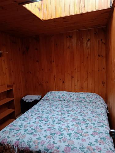 奥索尔诺Cabaña Interior con entrada independiente的木制客房内的一间卧室,配有一张床