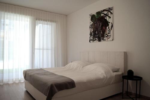 埃伦豪森Relax Residence Südsteiermark的白色的卧室设有床和窗户