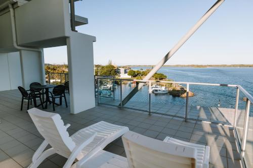 巴利纳Ramada Hotel & Suites by Wyndham Ballina Byron的阳台配有椅子,享有水景