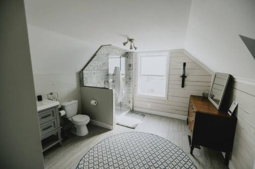 弗农Ultimate Relaxation Heritage Charmer的一间带水槽和卫生间的浴室以及一张书桌。
