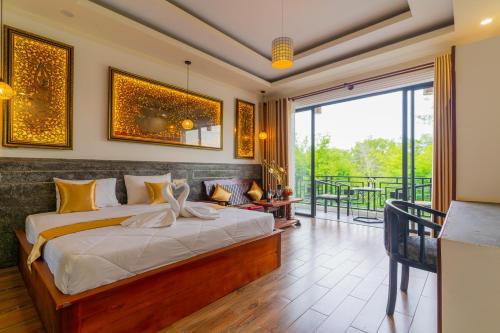 Phumĭ Ta PhŭlAngkor Rithy Residence的一间卧室设有一张床和一个阳台