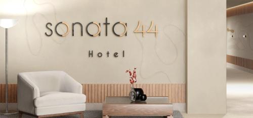 麦德林Sonata 44 Hotel Laureles的客厅配有白色椅子和桌子