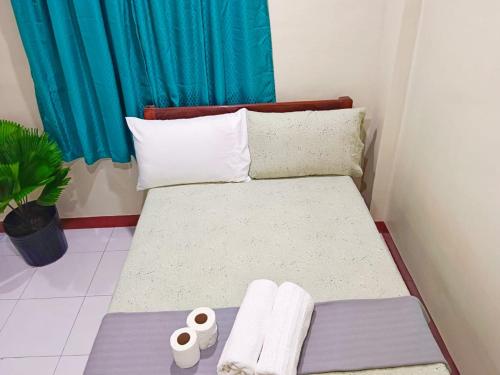 卢纳将军城#2 Green Room Inn Siargao的小房间,配有带毛巾的床