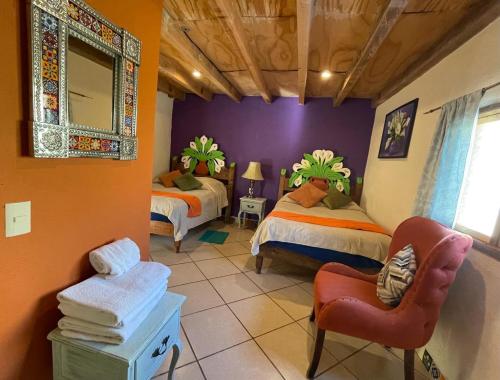 雷亚尔卡托尔塞Hotel Hacienda Encantada的一间卧室配有两张床、一把椅子和镜子