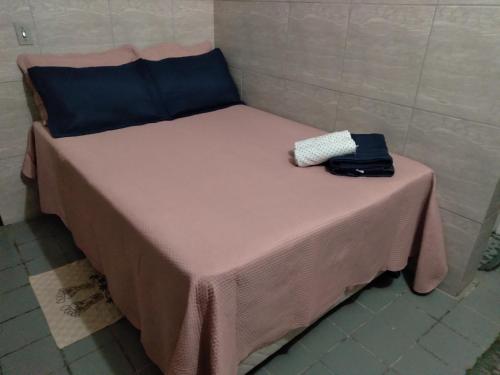 加利纽斯Pousada Pôr do Sol - Galinhos的一张带粉红色桌子的小床,上面有袋子