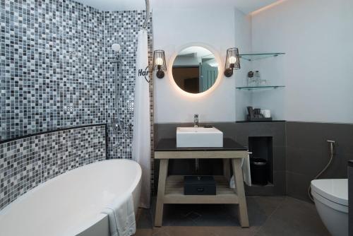库塔巴厘岛磐石酒店的带浴缸、水槽和镜子的浴室