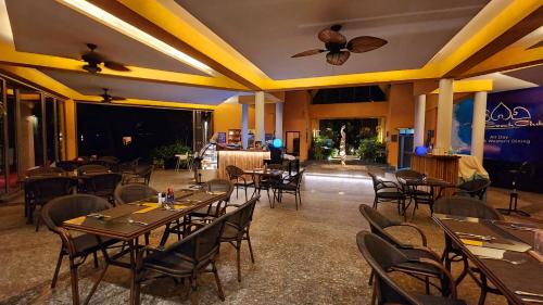 Ban Khlong SonKlong Son Resortel的一间带桌椅和天花板的餐厅
