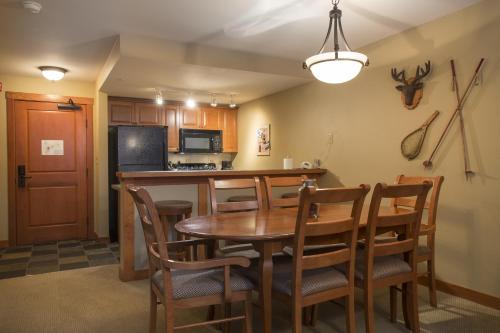 索利图德1310 - One Bedroom Den Standard Eagle Springs West condo的厨房以及带桌椅的用餐室。