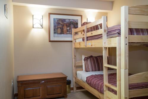 索利图德3406 - One Bedroom Den Standard Powderhorn Lodge condo的一间卧室设有两张双层床和一张桌子