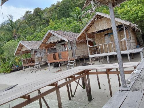 KriPasir timbul homestay的海滩上的一排竹屋