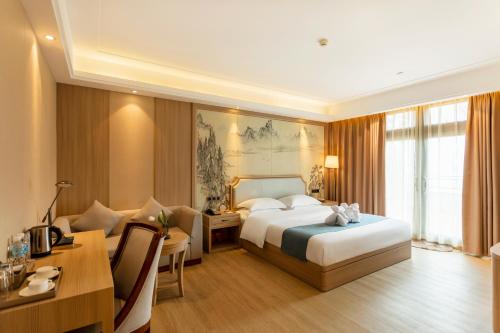 Lancang澜沧华隆大酒店的酒店客房配有一张床铺、一张桌子和一张书桌。