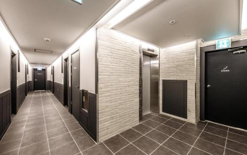 浦项Hotel Venesian的走廊设有黑色门,铺有瓷砖地板