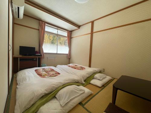 饭山市福泽勒夫雷旅馆的小房间设有床和窗户