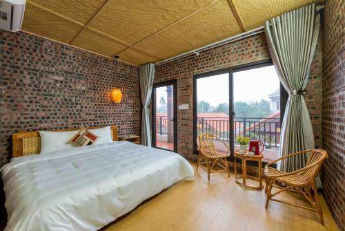 宁平Gia Nguyễn Homestay的一间卧室设有一张大床和砖墙