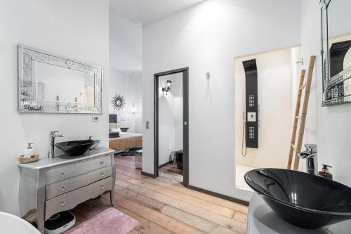 戛纳The Cosmopolitan Lodge的浴室设有黑色水槽和镜子