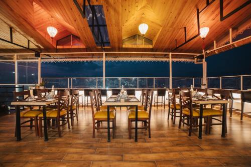 甘托克Zip By Spree Hotels Gangtok的餐厅设有木制天花板和桌椅