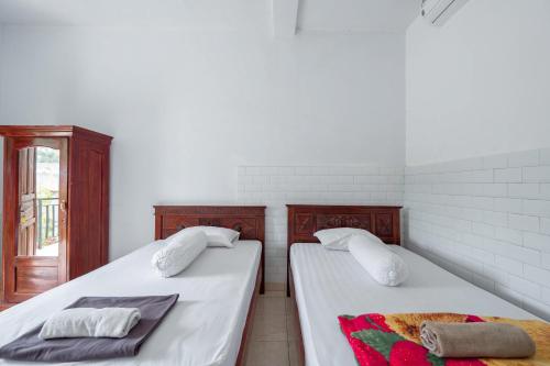 乌鲁瓦图SDK Homestay Uluwatu的两张睡床彼此相邻,位于一个房间里