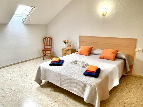 雷乌斯APARTBEACH EL PINAR CON PISCINA y BARBACOA的一间卧室配有一张大床和橙色枕头