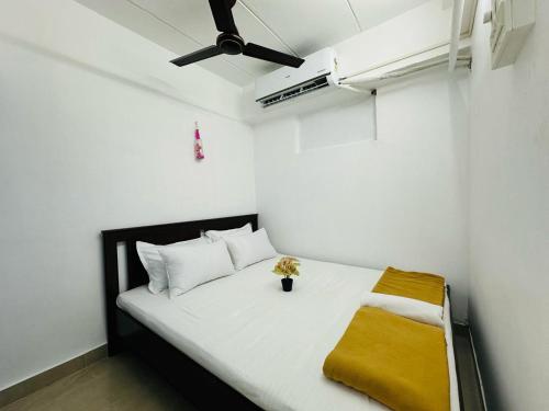 孟买1BR Apartment Parel的一间小卧室,配有一张白色的床和黄色的毯子