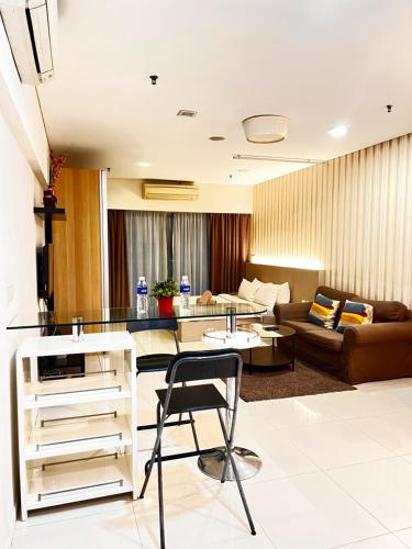 吉隆坡Summer Suites KLCC By Castle Classy的客厅配有桌子和沙发