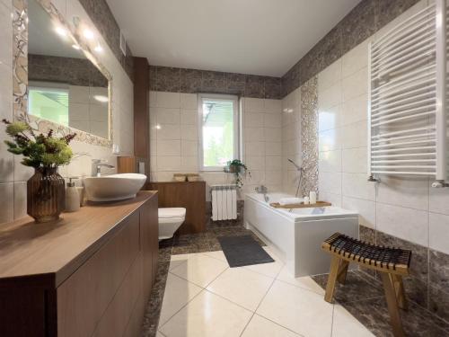 JasionkaGarden House - OSTOYA的带浴缸、盥洗盆和卫生间的浴室