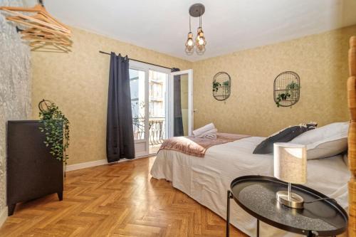 克莱蒙费朗Maison 15 couchages idéale pour séjour en groupe的一间卧室配有一张床、一张桌子和一个窗户。