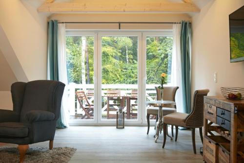 于克里茨Strandhäuser Blankenfohrt的客厅设有滑动玻璃门、桌子和椅子