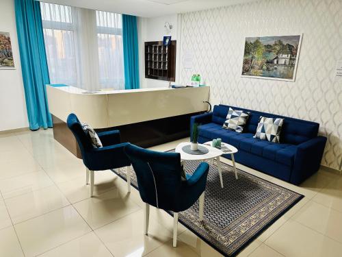图兹拉HOTEL MINERO的客厅配有蓝色的沙发和钢琴