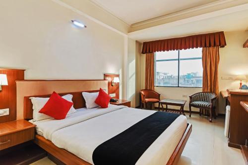 斋浦尔Hotel Royal Empire的酒店客房配有一张带红色枕头的大床