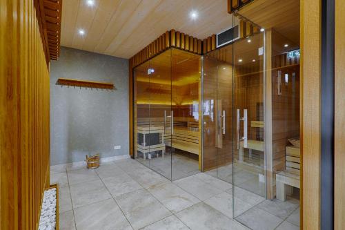 于克里茨Strandhäuser Blankenfohrt的一间带玻璃淋浴的浴室和一台电视
