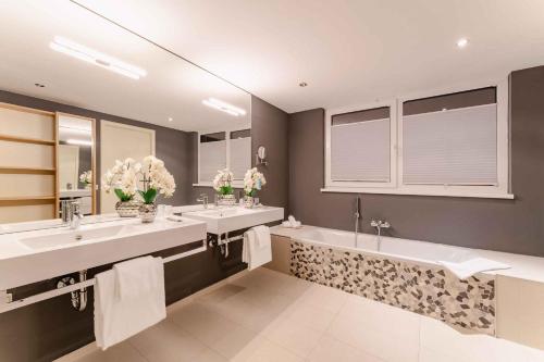 格拉茨PLAZA INN Graz的浴室设有2个水槽和2面镜子
