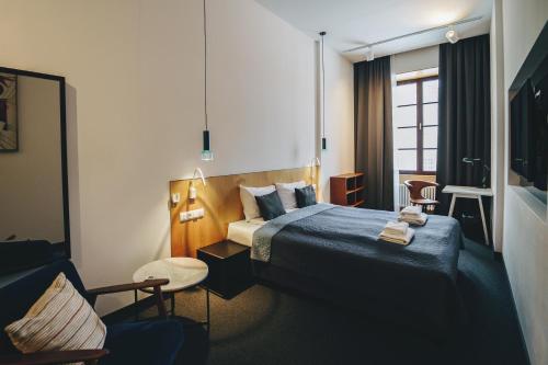 卢布林Avatary Miasta的配有一张床和一把椅子的酒店客房