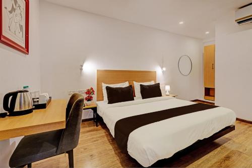 新德里Ocean Suites Near Delhi International Airport的酒店客房配有一张床、一张书桌