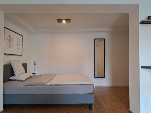 卡塞尔Souterrain-Apartment in Wehlheiden Kassel的白色卧室配有床和镜子