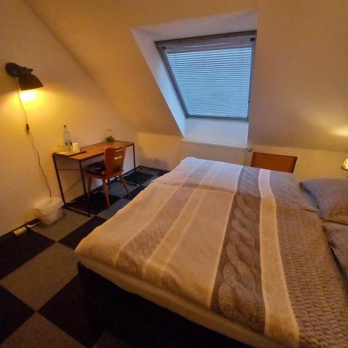 阿尔夫Zur alten Metzgerei的一间卧室配有一张床、一张书桌和一个窗户。