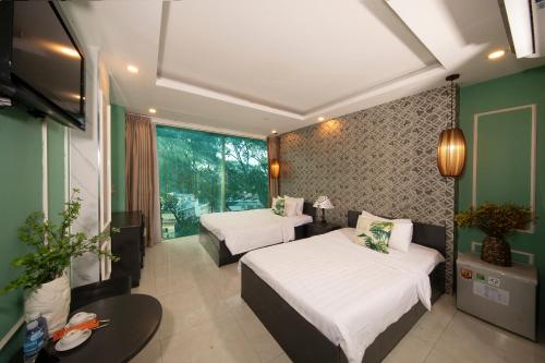 胡志明市Vintage Boutique Hotel & Spa的酒店客房设有两张床和电视。
