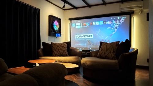 本部Cinema Resorts 1的客厅配有两把椅子和投影屏幕