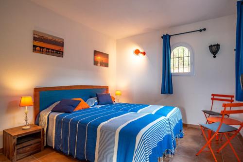 维琪奥港圣朱利亚乡村度假屋酒店的卧室配有蓝色和白色的床和椅子