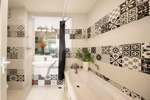胡志明市Vintage Boutique Hotel & Spa的浴室的墙壁上铺有黑白瓷砖。