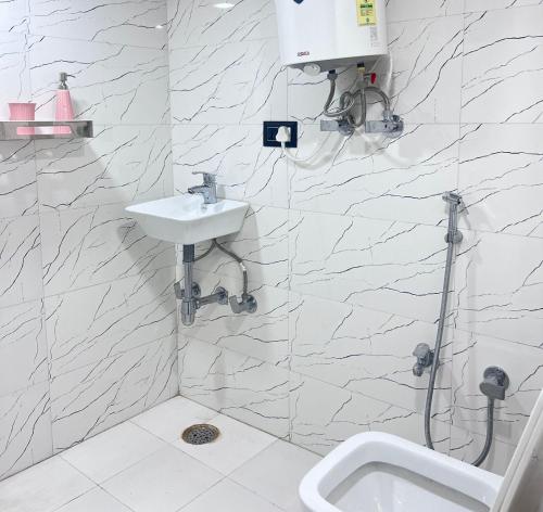 乌代浦3 Raahi的白色的浴室设有水槽和淋浴。