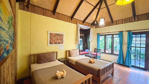 罗勇Villa Bali Eco Resort, Rayong的一间客房内配有两张床的房间