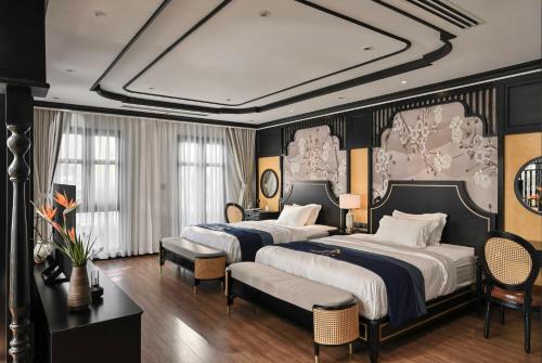 Bạc LiêuThiên Ân Boutique Hotel的酒店客房,设有两张床和一张沙发