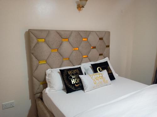 Kitengela Mellow Homes 1 & 2 Bedrooms fully furnished Apartment的一间卧室配有带枕头的床