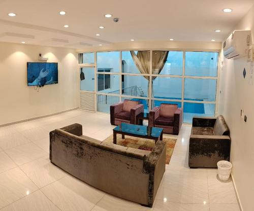 塔伊夫منتجع الكناري للفلل الفندقية الفاخرة Canary resort的客厅配有沙发和两把椅子