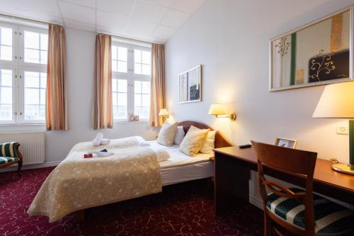 米泽尔法特Milling Hotel Park的配有一张床和一张书桌的酒店客房