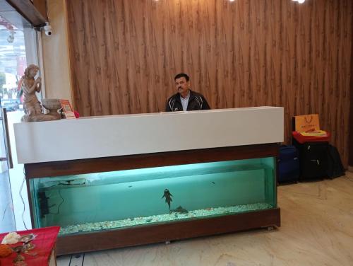 瓜廖尔Hotel Sun Beam Near Gwalior Railway Station的站在一个大鱼缸旁的人
