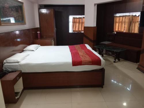 瓜廖尔Hotel Sun Beam Near Gwalior Railway Station的一间卧室配有一张大床和一张沙发