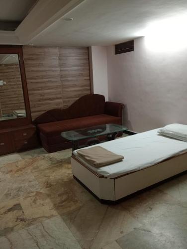 瓜廖尔Hotel Sun Beam Near Gwalior Railway Station的客厅配有床和沙发